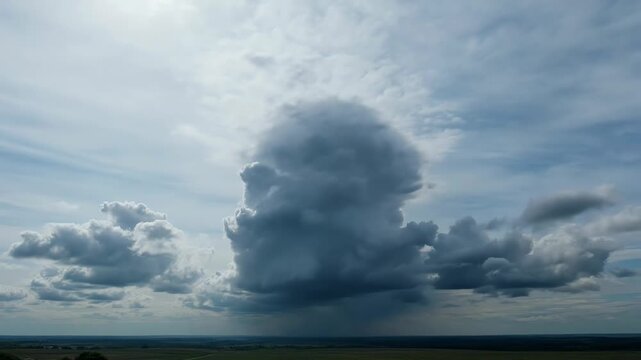 Towering Cumulonimbus Cloud Formation Producing Rain Over Rural Landscape