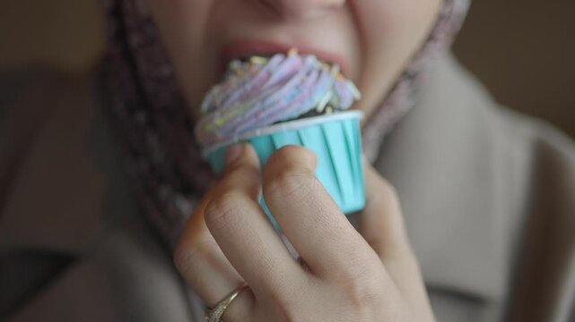 Enjoying a colorful cupcake in a cafe
