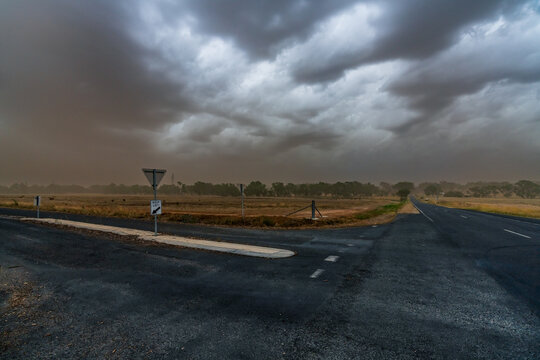 A summer dust storm approaching over country roads and dry farmland