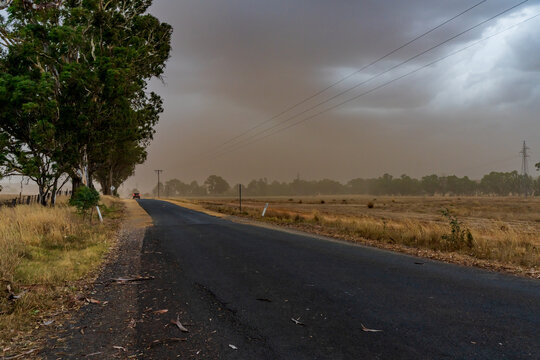 A summer dust storm approaching over country road and dry farmland