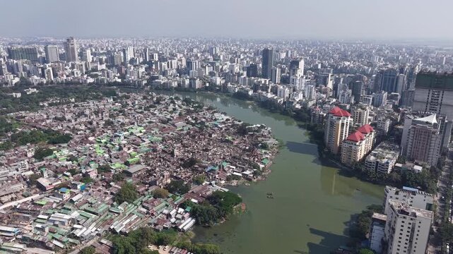 Drone perspective of a sprawling slum settlement bordering a city waterway