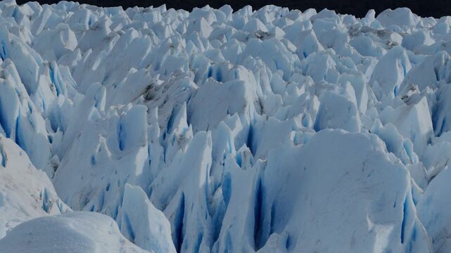 Fractured glacial surface on Perito Moreno Glacier in Los Glaciares National Park, Santa Cruz, Argentina, features towering s&eacute;racs, crevasses and compressed blue ice, drone lateral slide.