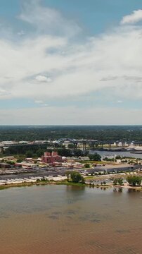 A forward vertical aerial shot showcasing the industrial landscape, riverfront, and the iconic Leo Frigo Memorial Bridge in Green Bay, Wisconsin.