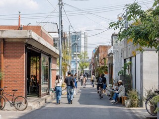 Fototapeta premium Relaxed afternoon alley in Seoul with brick buildings cafes and pedestrians