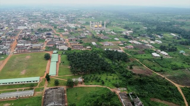 Aerial view of a mosque with golden domes surrounded by residential buildings, lush greenery, and open fields in Aiyepe, Ogun State, Nigeria.