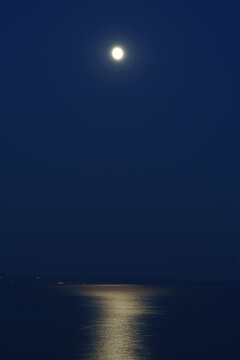 Bright full moon illuminating the calm waters of the Adriatic Sea with a shimmering moonlight reflection stretching across the surface
