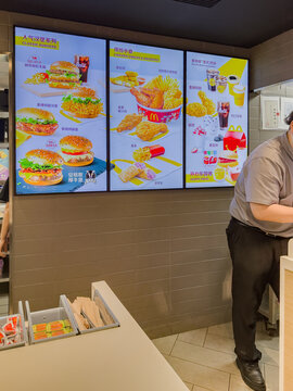 Shanghai, China &mdash; 05-26-2026: Modern interior of a McDonald's restaurant with digital menu boards and dining area, reflecting global fast-food culture in an urban environment