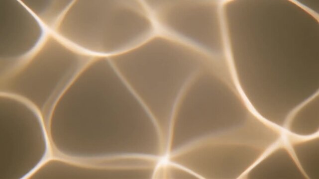 Golden light patterns dance on a warm surface with abstract shapes