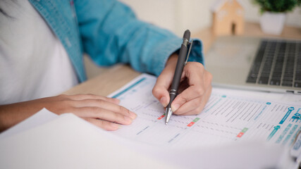 Naklejka premium Business professional reviewing performance reports and auditing stack of documents at office desk. Concept of corporate audit, compliance check, data analysis, and financial reporting process.