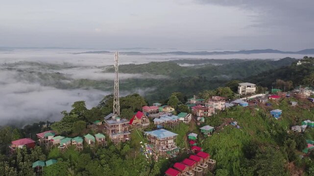 Drone view of Sajek Valley resorts and cell tower on a misty mountain ridge