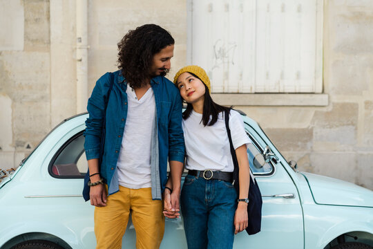 Young couple in love standing at small car