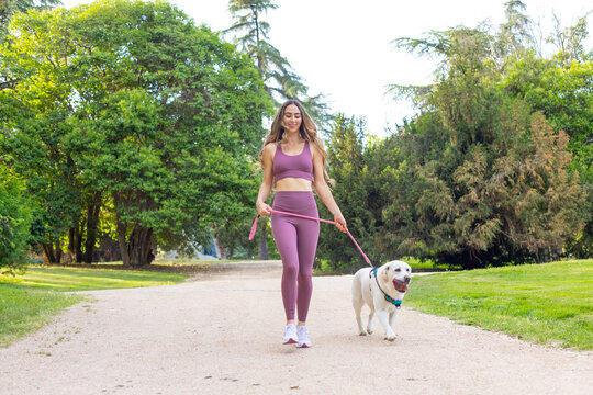 Young woman enjoying outdoor walk with labrador dog