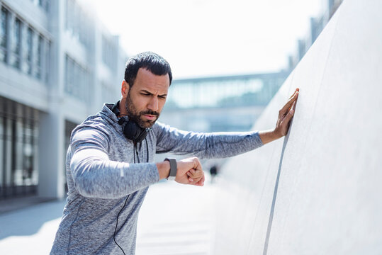 Man having a break from exercising looking on smartwatch