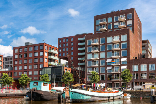 Modern brick building and houseboat at Westerdok canal in Amsterdam