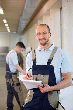Craftsman in workshop taking notes