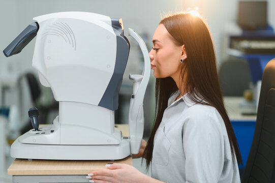 Woman getting vision test with modern optometry equipment