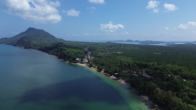 Cinematic Drone aerial showcasing a remote tropical coastline with lush coastal forest sandy shoreline and distinctive island formations along Koh Jum in Krabi Province Thailand Andaman Sea.