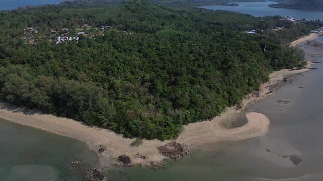 Cinematic Drone aerial showcasing a remote tropical coastline with lush coastal forest sandy shoreline and distinctive island formations along Koh Jum in Krabi Province Thailand Andaman Sea.