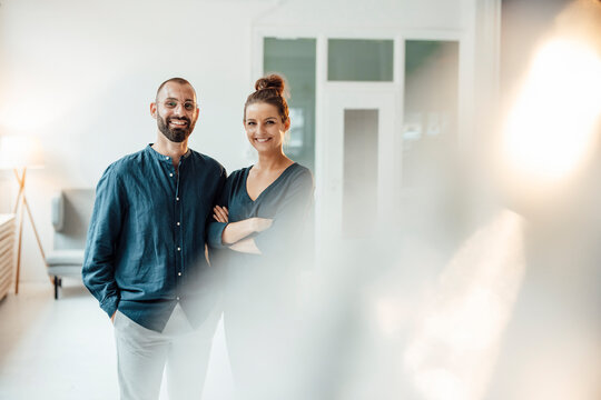 Happy business couple standing together at home office