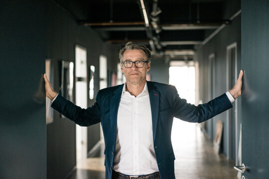 Portrait of mature businessman standing on office floor