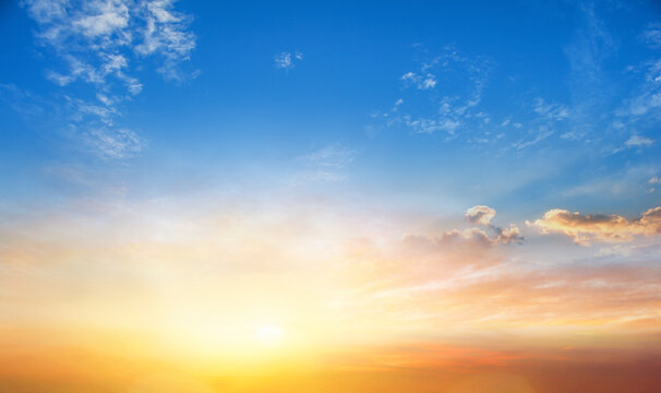 Sunset sky background with tiny clouds and rays of light shining through the clouds
