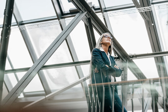 Woman with long grey hair standing in a loft