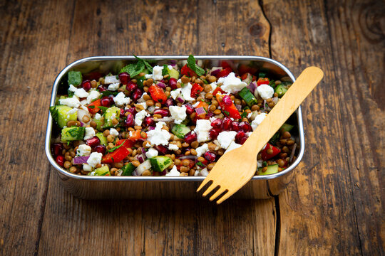 Lentil salad with feta and pomegranate in stainless steel lunchbox