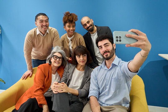 Smiling team of colleagues taking a selfie in the office