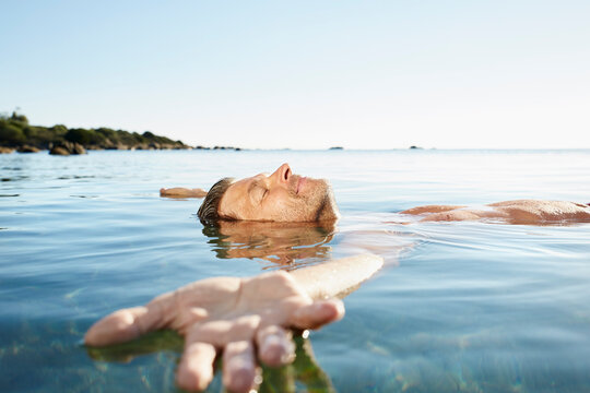Relaxed mature man floating in the sea