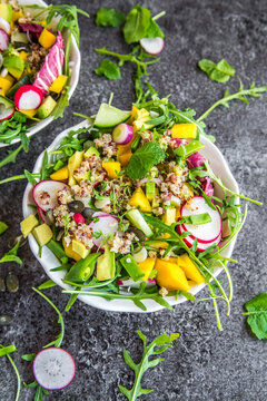 Mango quinoa salad with rocket, avocado, cucumber, red radishes and pumpkin seeds