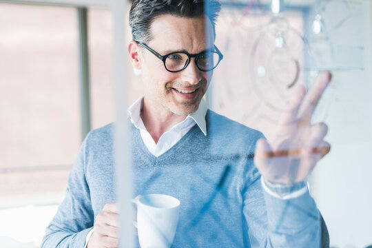 Businessman touching transparant projection screen in office