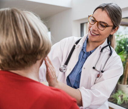 Smiling nurse caring for senior patient indoors