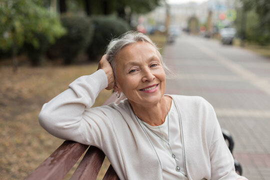 Portrait of smiling senior woman relaxing on a bench