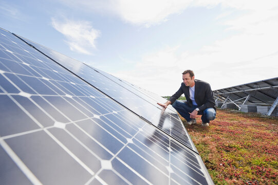 Person inspecting solar panels at photovoltaic plant outdoors in Munich