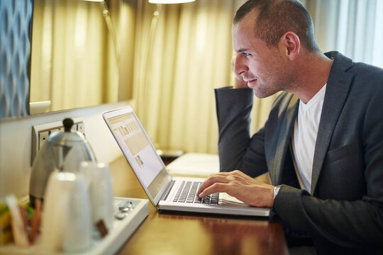 Businessman using laptop in hotel room