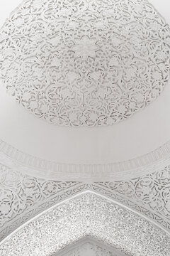 White carved plaster dome ceiling inside Muhammad Amin Khan Madrasa in Khiva Uzbekistan. Intricate floral stucco ornamentation in Ichan Kala historic fortress. Ideal for architecture, heritage.