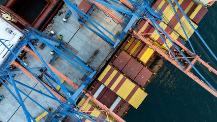 Fototapeta premium Aerial view container ship loaded with cargo box at commercial port terminal, Global business logistic international trade maritime transportation by container ship, Container ship at commercial port.