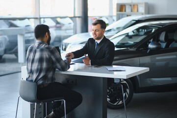 Car salesperson giving new keys to happy buyer © Serhii