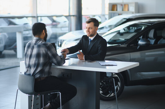 Car salesperson giving new keys to happy buyer