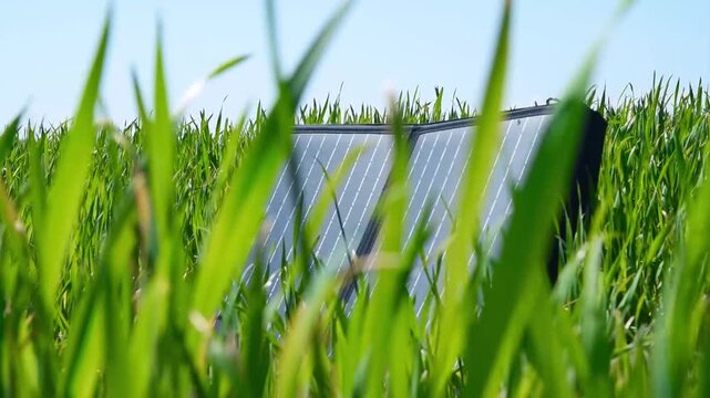 Portable solar panel standing in a green field. Renewable energy source for sustainable power generation. Eco-friendly technology for off-grid electricity and environmental conservation.