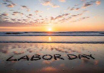 Labor day written on sandy beach at sunset