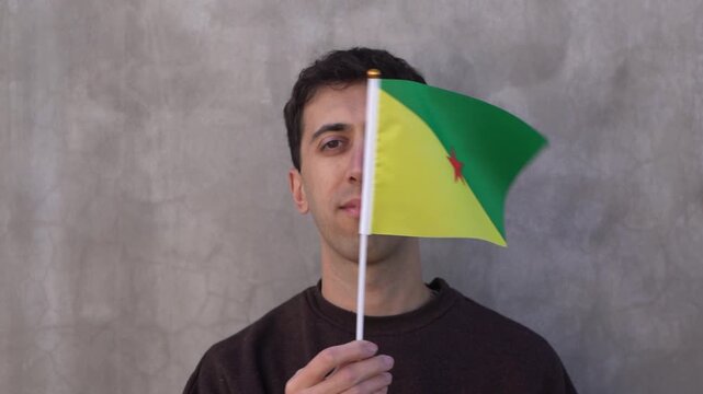 Man waving the Guianese flag. Close up in slow motion.