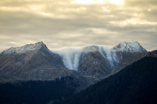 Panoramic View of Dramatic Snow Covered Mountain Peaks with Ethereal Cascading Clouds in the Pindus Range of Metsovo Greece