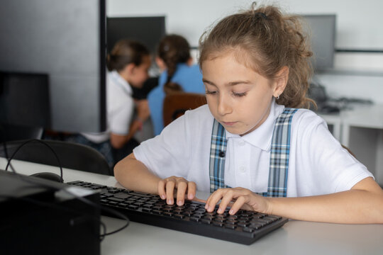 Elementary School Girl Typing on Computer Keyboard