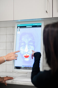 Aesthetics practitioner discussing skin analysis results during client consultation