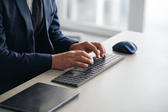 A male business professional using a PC keyboard. DX, desk work, office work, business, IT, typing.