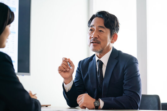 面談する男女ビジネスパーソン。コンサル、アドバイザー、上司、会議、ビジネス、相談、研修、指導、経営者