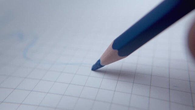 Extreme Macro of a pencil color Tip Making Freehand Strokes on Graph Paper in an Exercise Book, Highlighting Writing, Learning, Stationery, and Creative Expression