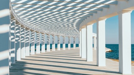 Fototapeta premium Architectural pergola framing ocean, creating repeating patterns of light and shadow on a curved pathway under a clear blue sky