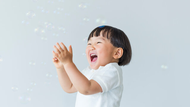 シャボン玉に手を叩いて喜ぶ3歳の男の子